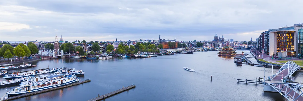 Amsterdams Oosterdok von oben mit Ausflugsbooten und der Silhouette der Altstadt mit den Türmen der Nikolaikirche