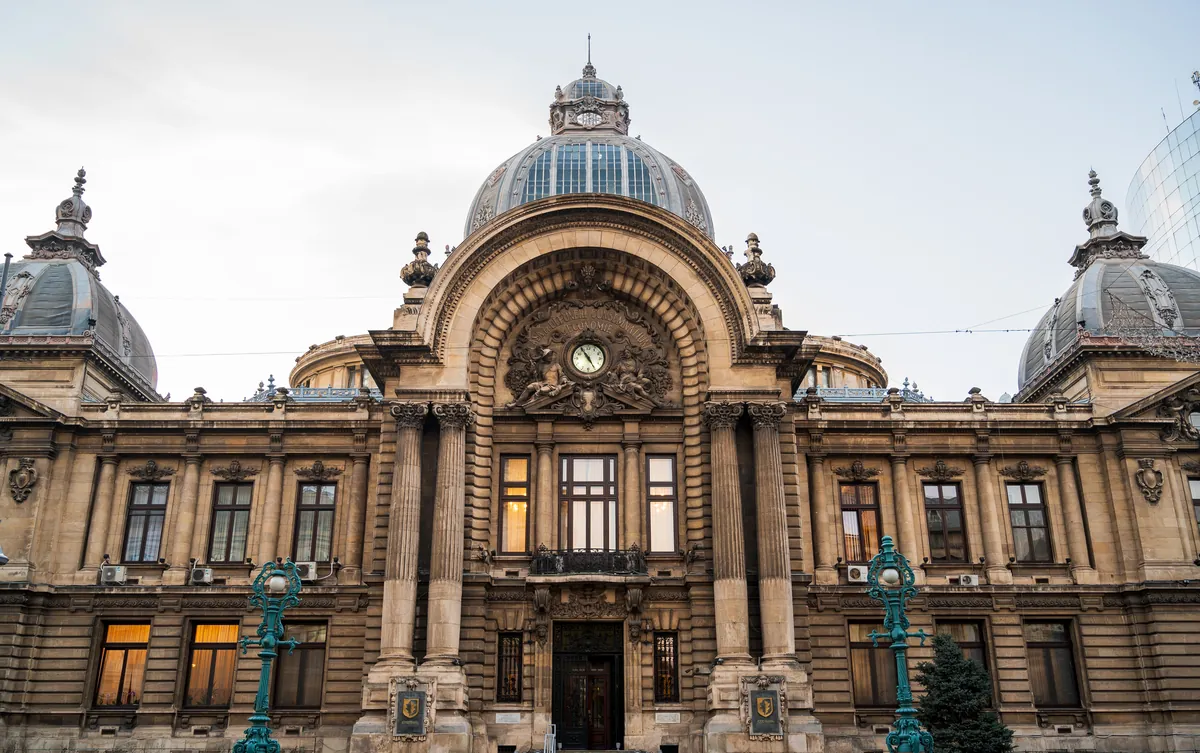 Die Beaux-Arts-Fassade des CEC-Palastes in Bukarest mit der zentralen Glaskuppel, Uhr und zwei Eckkuppeln